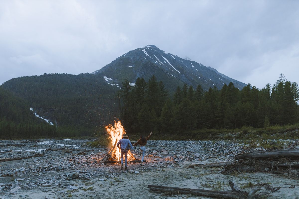Paar am Lagerfeuer in den Bergen